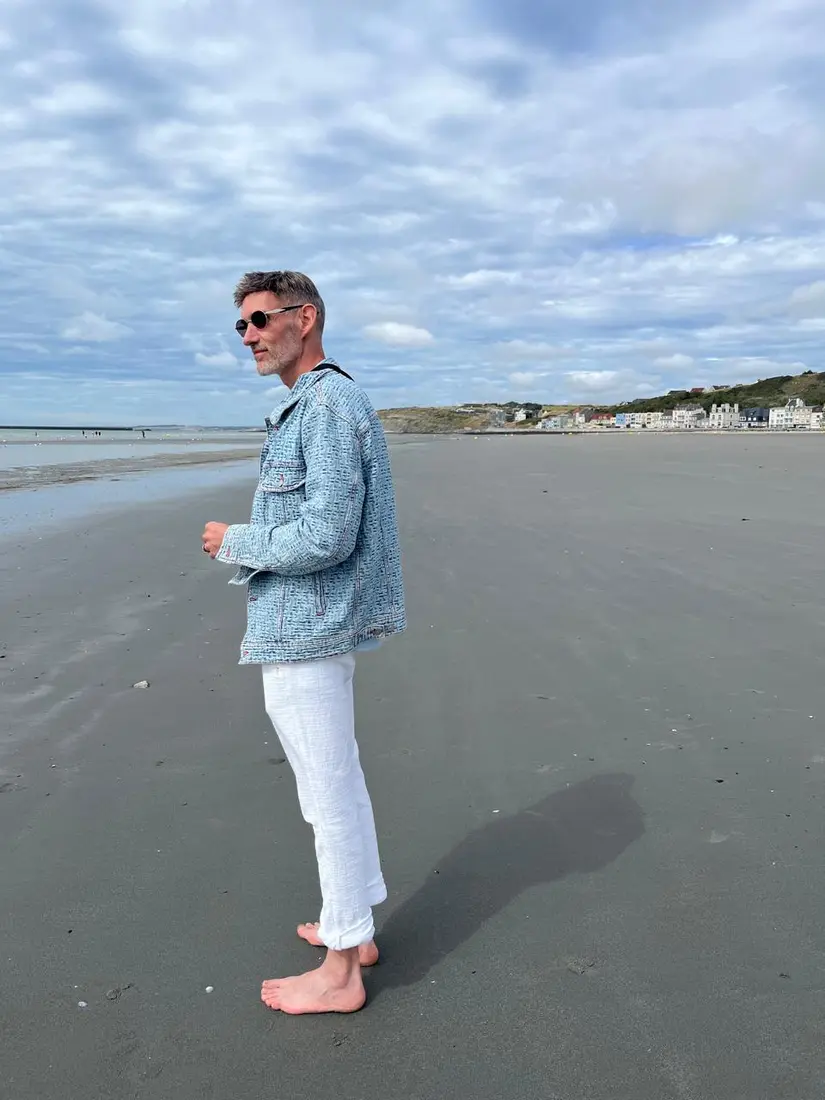 Pierre marchant sur une plage, face à l’horizon